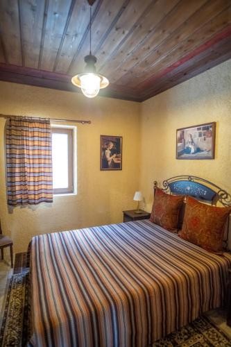 a bedroom with a large bed with a striped blanket at okakosolykos in Kostitsi