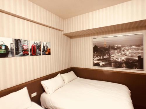 a room with a bed and a picture of a city at Love Feng Jia Apartment Hotel in Taichung