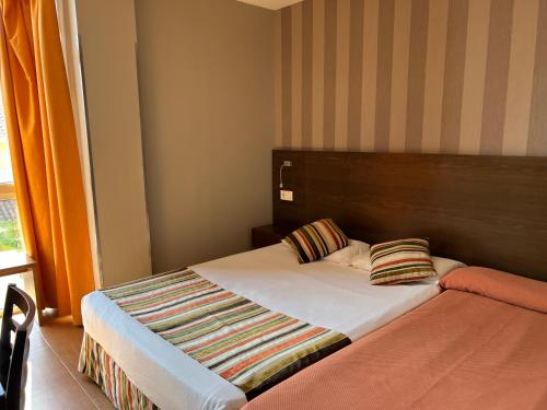 a bed with two pillows on it in a room at Hostal Los Coronales in Madrid