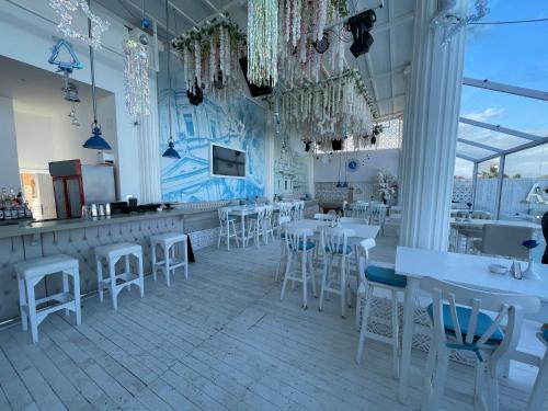 um restaurante com mesas brancas e bancos brancos em Beautiful 1-Bed Apartment em Hurghada