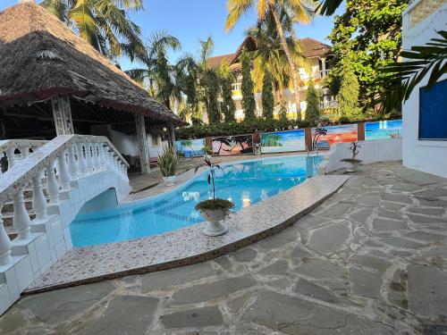 een resortzwembad met een trap en een gebouw bij Charming and Remarkable 1 Bed Villa in Diani Beach in Diani Beach