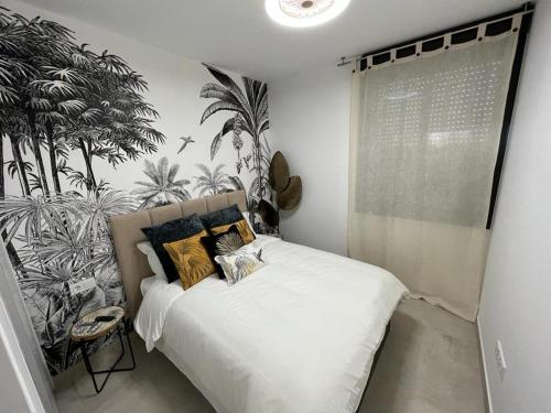 a bedroom with a white bed with plants on the wall at Outstanding 2 bed apartment with rooftop sea views in Mar de Cristal