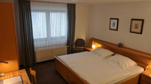 um quarto de hotel com uma cama e uma janela em Apparthaus Arosa em Essen