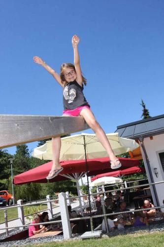 a girl standing on a surfboard on a board at Landhotel Kleblmühle in Grafenau