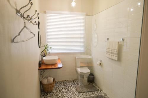 a white bathroom with a toilet and a sink at The Lemon Tree in Ceres