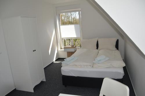 a small bedroom with a bed and a window at Ferienhaus Tini in Wirdum