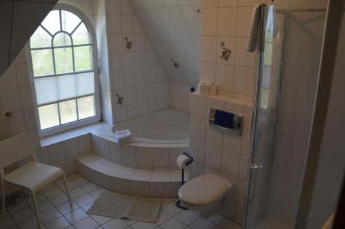 a bathroom with a tub and a toilet and a shower at Ferienhaus Tini in Wirdum