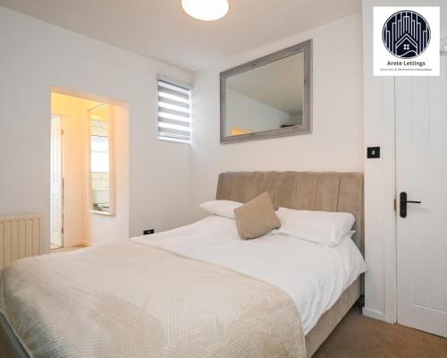 um quarto com uma cama e um espelho na parede em SPECIAL PROMO! Perfect Group Accommodation, 3 Bathrooms Perfect for Contractors and Businesses with relocation Requirement near Harwich Sea Port em Harwich