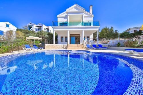a large swimming pool in front of a house at James Pansiyon Blue sea view villas Kaş Peninsula in Kas