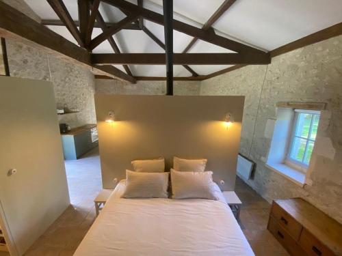 a bedroom with a large white bed in a room at Beautiful riverside boathouse in Bourg-Charente