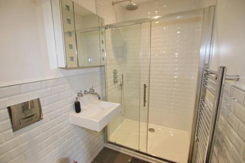 a white bathroom with a sink and a shower at Modern Home for Small Groups by Stones Throw Apartments - Free Parking - Sea View in Worthing