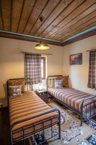 a bedroom with two beds and a wooden ceiling at okakosolykos in Kostitsi