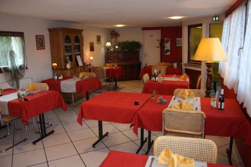 a restaurant with red tables and chairs in a room at Contact Hôtel Arc-En-Ciel - Réouverture - Rénové in Mulhouse