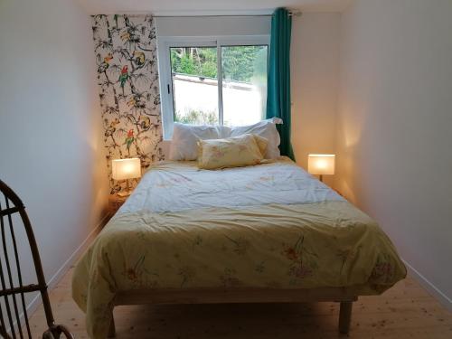 ein Schlafzimmer mit einem Bett mit zwei Lampen und einem Fenster in der Unterkunft La Polaris in Angerville-lʼOrcher