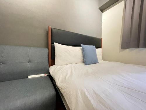 ein Schlafzimmer mit einem Bett mit einem blauen Kissen darauf in der Unterkunft 一中自在居 in Taichung