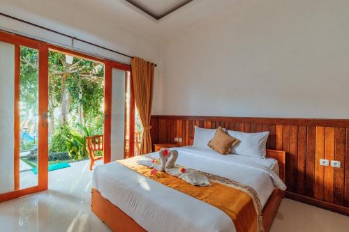 um quarto com uma cama com um bicho de peluche em Green Valley em Nusa Penida