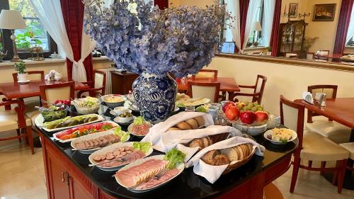 a table with many plates of food on it at Hotel Wenus in Kazimierz Dolny