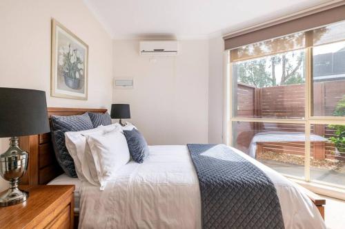 a bedroom with a bed and a window at Design/bright/cosy townhouse between airport &city in Melbourne