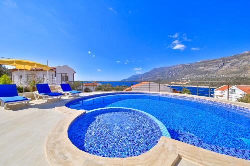 uma grande piscina com água azul num quintal em Blue Sea View Villas - Kas Peninsula em Kas