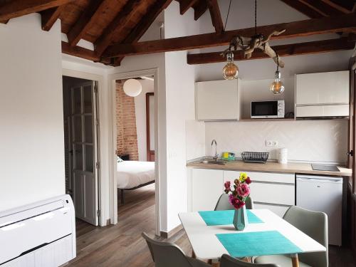 a kitchen and dining room with a table and chairs at Apartamentos Boutique Granada 3000 in Granada