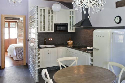 a kitchen with a table and a white refrigerator at Casas Rurales TAReira en Taramundi in Taramundi