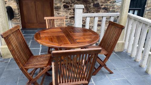 a wooden table and chairs sitting on a porch at Casas Rurales TAReira en Taramundi in Taramundi