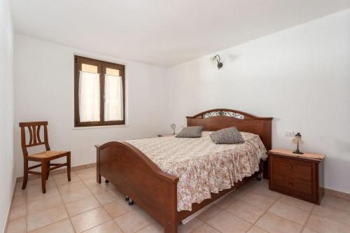 a bedroom with a bed and a chair and a window at Funtana Meiga, il tuo angolo di paradiso in Funtana Meiga