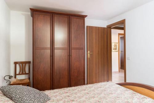 a bedroom with a wooden cabinet and a bed at Funtana Meiga, il tuo angolo di paradiso in Funtana Meiga