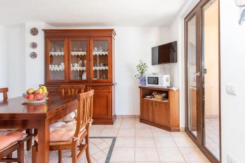 a kitchen with a wooden table and a dining room at Funtana Meiga, il tuo angolo di paradiso in Funtana Meiga