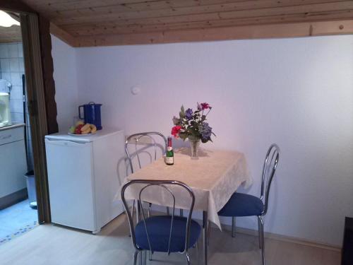 einen Tisch mit Stühlen und eine Vase mit Blumen darauf in der Unterkunft Ferienwohnung Anita Bernhardt in Rimbach