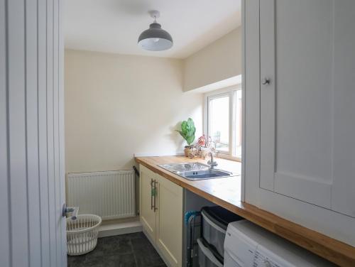 a small kitchen with a sink and a window at Maenan in Criccieth