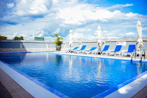 a swimming pool with blue chairs and a group at Urban Park Suites in Kigali