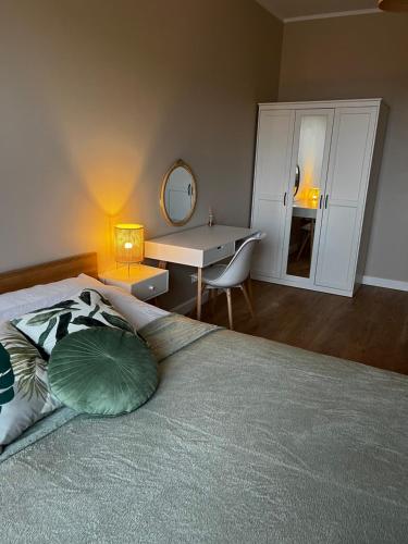 a bedroom with a bed with a desk and a mirror at Żołnierska Olsztyn in Olsztyn