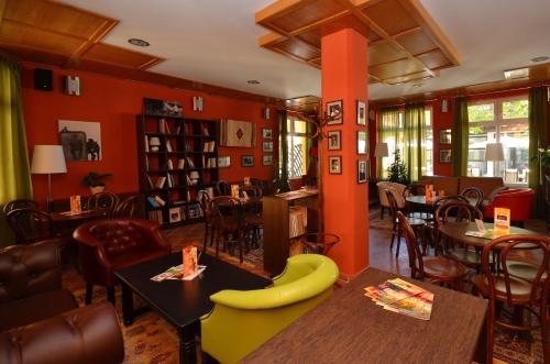 a restaurant with orange walls and tables and chairs at Art Garni Hotel in Kanjiža