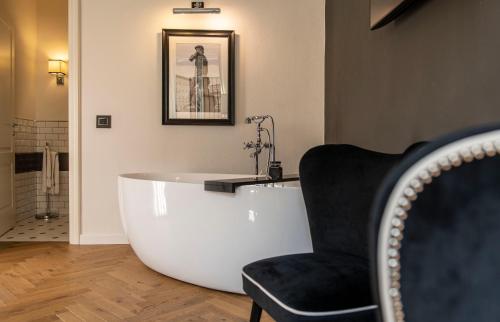 a bath tub in a room with a chair at Relais Uffizi in Florence