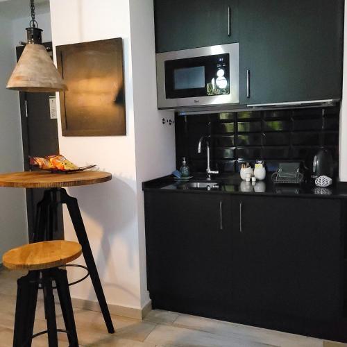a kitchen with a black counter and a microwave at Terrace Costa Hotel in Fuengirola