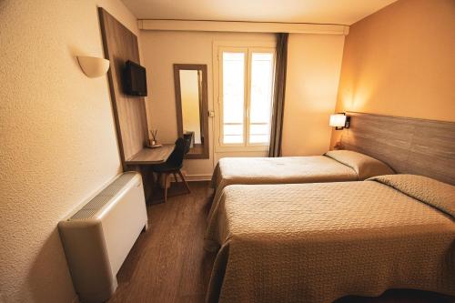 a hotel room with two beds and a desk at Hôtel le Panoramic - Votre Hôtel au cœur des Gorges du Verdon in La Palud sur Verdon