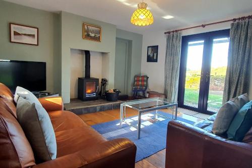a living room with a couch and a fireplace at Westdale Cottage, Elton in the Peak District in Elton