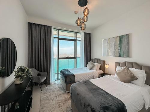 a hotel room with two beds and a large window at Luton Vacation Homes - Full Sea and Palm View & Modern 2BR - Emaar Beachfront , Beach Vista, Dubai Harbour - 17AB06 in Dubai