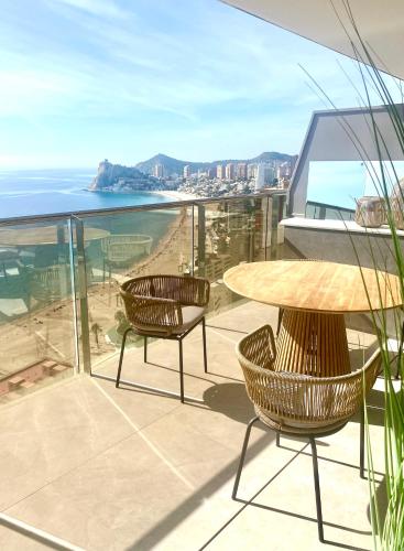 a balcony with a table and chairs and the ocean at Sunset Cliffs Luxury Apart with Sea View in Benidorm