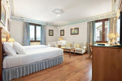sypialnia z dużym łóżkiem i salonem w obiekcie Hotel Inglaterra w Sewilli