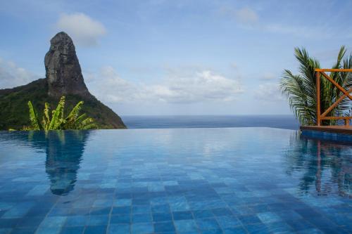 a swimming pool with a view of the ocean at Pousada Ecológica Akanã in Fernando de Noronha