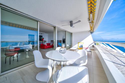 une salle à manger blanche avec vue sur l'océan dans l'établissement SUNNY, à Villeneuve-Loubet