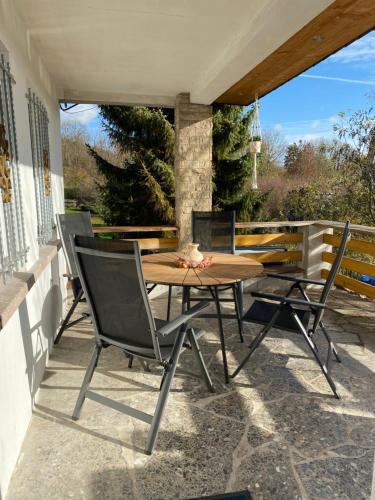 a wooden table and chairs on a patio at Ferienhaus Naturblick in Bad Frankenhausen