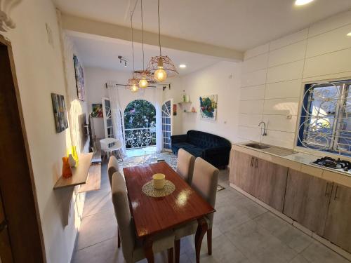 a kitchen and living room with a wooden table and chairs at Dolce Vita Palacio in Douala