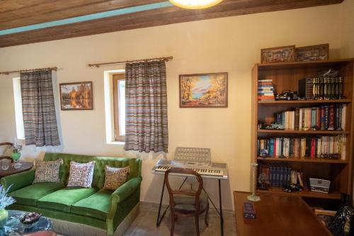 a living room with a green couch and a table at okakosolykos in Kostitsi