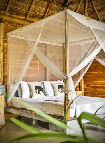 a bed in a tent with white pillows at Gal Oya Lodge in Galgamuwa