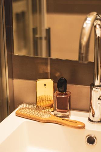 a bathroom sink with a toothbrush and a bottle of perfume at Hôtel le Panoramic - Votre Hôtel au cœur des Gorges du Verdon in La Palud sur Verdon
