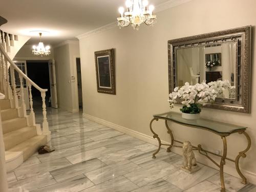 a living room with a table and a mirror at Cosy private room easy access to city & airport in Melbourne