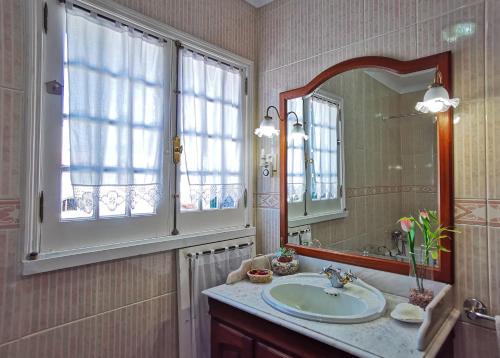 a bathroom with a sink and a mirror at Pico do Moinho House in Fajã de Baixo